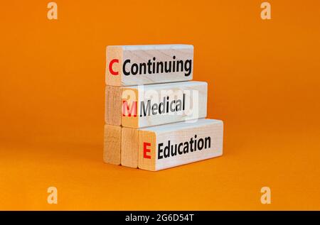 CME, simbolo della formazione medica continua. Blocchi di legno con le parole CME, continuando l'educazione medica su sfondo arancione bello. Business, CME, co Foto Stock
