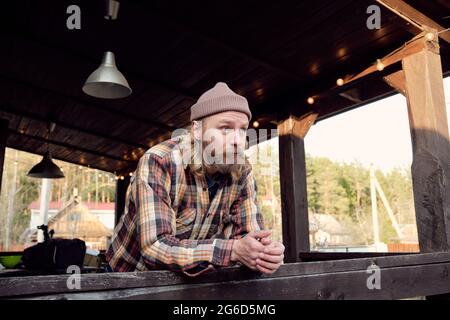 Giovane contadino bearded in piedi sulla terrazza e godendo la natura nel paese Foto Stock