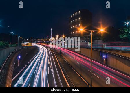 Autobahn 100 in direzione di Messedamm Berlino di notte con i fari, autostrada 100 a Berlino germania, piste di luce, radio Tower Berlin a Backgrou Foto Stock