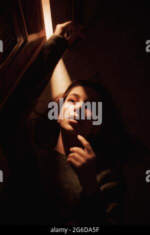 Uomo maturo con abiti casual e moderni occhiali di protezione VR neri che sperimentano la realtà virtuale mentre si siede nella stanza luminosa di casa Foto Stock