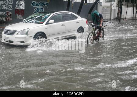 Dhaka, Bangladesh. 04 luglio 2021. Un ciclista fa la sua strada durante una pioggia. Il paese è entrato in un blocco rigoroso e pesante monsone downpour ha causato il disboscamento estremo di acqua nella maggior parte delle zone della città di Dhaka, il Bangladesh. Le strade sono state sommerse rendendo la marcia lenta e pericolosa. Credit: SOPA Images Limited/Alamy Live News Foto Stock