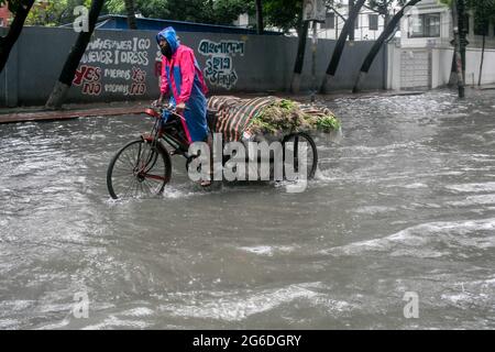 Dhaka, Bangladesh. 04 luglio 2021. Un ciclista fa la sua strada durante una pioggia. Il paese è entrato in un blocco rigoroso e pesante monsone downpour ha causato il disboscamento estremo di acqua nella maggior parte delle zone della città di Dhaka, il Bangladesh. Le strade sono state sommerse rendendo la marcia lenta e pericolosa. Credit: SOPA Images Limited/Alamy Live News Foto Stock