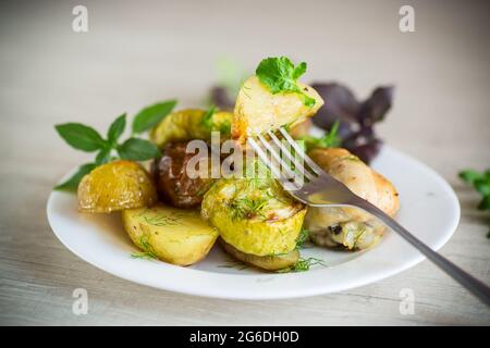 Patate al forno con zucchine e pollo Foto Stock