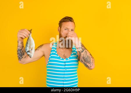 l'uomo con la barba e il costume da bagno catturò un pesce Foto Stock