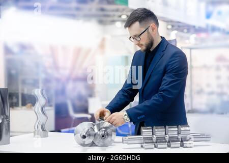 Il tecnico controlla le dimensioni con calibro a corsoio al dettaglio della finitura dopo la lavorazione dei metalli su macchine utensili cnc. Qualità di controllo concettuale del prodotto Foto Stock