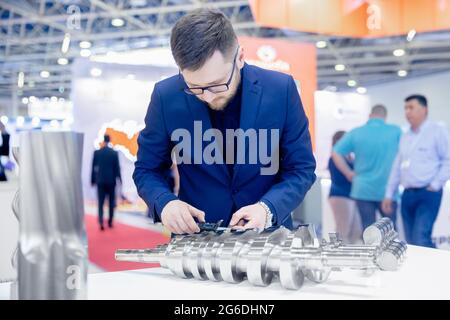 Il tecnico controlla le dimensioni con calibro a corsoio al dettaglio della finitura dopo la lavorazione dei metalli su macchine utensili cnc. Qualità di controllo concettuale del prodotto Foto Stock