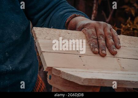 Primo piano di una vecchia donna mano pittura su un oggetto di legno Foto Stock