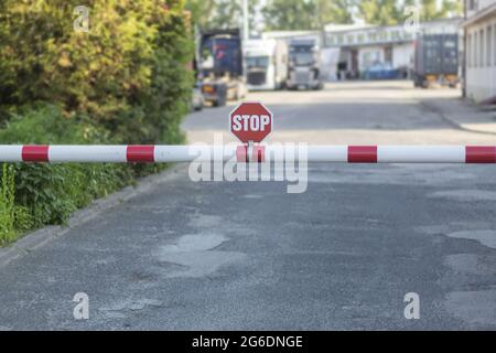 Barriera e segnale di stop sulla strada. Ingresso al cancello dell'organizzazione, al checkpoint e al cartello di stop Foto Stock