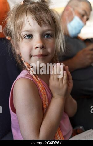 carino bambina con i pigtail sull'aereo. Foto Stock