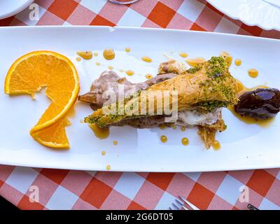 Delizioso dolce tradizionale turco baklava in piatto con frutta sul tavolo Foto Stock