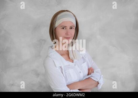 Ritratto di una donna sorridente di 50 anni con sciarpa in capelli Foto Stock