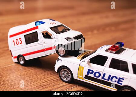 Collisione di Toy Ambulance Auto e polizia su pavimento in legno closeup Foto Stock