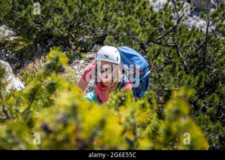 Giovane escursionista con casco durante l'escursione a Hochkalter, Berchtesgadener Alpen, Berchtesgadener Land, alta Baviera, Baviera, Germania Foto Stock