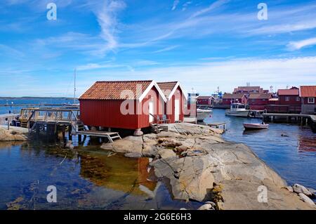 Rocce, boathouses e case di legno sull'isola dell'arcipelago di Gullholmen, Svezia Foto Stock
