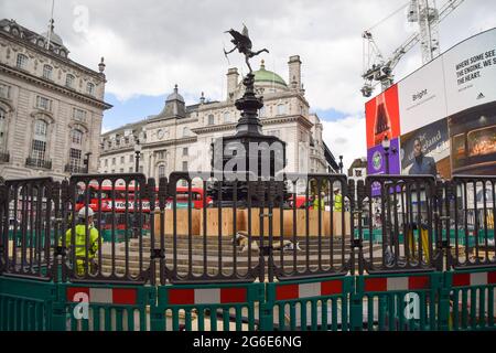 Londra, Regno Unito. 05 luglio 2021. I lavoratori hanno visto salire a bordo della Shaftesbury Memorial Fountain, nota anche come Eros, a Piccadilly Circus prima delle semifinali e finali Euro 2020.il monumento di Londra è stato imbarcato prima delle restanti partite di calcio per proteggere il monumento e impedire ai tifosi di arrampicarlo, Come grandi folle si sono radunate su e intorno al punto di riferimento dopo le recenti vittorie inglesi nel campionato di calcio. Credit: SOPA Images Limited/Alamy Live News Foto Stock