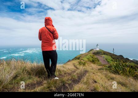 Guy davanti al faro di Cape Reinga, Capo Reinga, te Rerenga Wairua, Northland, Isola del Nord, Nuova Zelanda Foto Stock