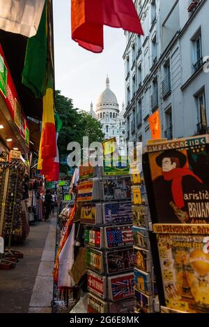 Via con negozi di souvenir a Montmartre con la Basilica del Sacro cuore sullo sfondo, Parigi, Francia Foto Stock