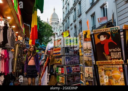 Via con negozi di souvenir a Montmartre con la Basilica del Sacro cuore sullo sfondo, Parigi, Francia Foto Stock