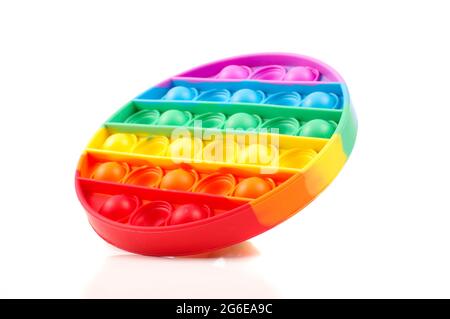 Giocattolo Popit per il relax e l'intrattenimento dei bambini. Arcobaleno multicolore rotondo isolato su sfondo bianco Foto Stock