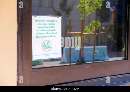 Accedi a una finestra presso un bar che avvisa i clienti che è illegale consumare cannabis o marijuana secondo le normative dello stato della California; San Jose, California. Foto Stock