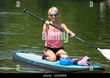 Acworth, Georgia, Stati Uniti. 4 luglio 2021. Una donna di 64 anni naviga sul lago Allatoona, Georgia, su una tavola da paddle per rimanere in salute e fisicamente in forma. Credit: Robin Rayne/ZUMA Wire/Alamy Live News Foto Stock