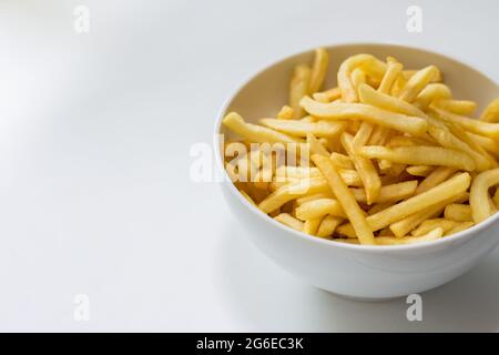 Ciotola completa di patatine fritte su fondo bianco Foto Stock