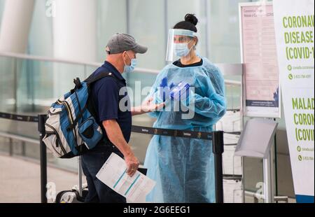 Mississauga, Canada. 5 luglio 2021. Il 5 luglio 2021, un viaggiatore preleva un kit COVID-19 presso l'aeroporto internazionale Pearson di Toronto a Mississauga, Ontario, Canada. A partire da lunedì, i canadesi e i residenti permanenti 'completamente vaccinati' possono entrare in Canada senza essere sottoposti a quarantena. Credit: Zou Zheng/Xinhua/Alamy Live News Foto Stock