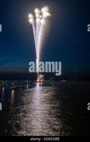 Fuochi d'artificio il 4 luglio sparato da una chiatta su un lago. Foto Stock