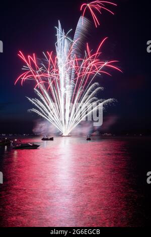 Fuochi d'artificio il 4 luglio sparato da una chiatta su un lago. Foto Stock