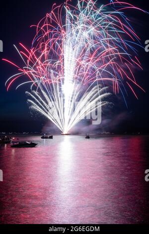 Fuochi d'artificio il 4 luglio sparato da una chiatta su un lago. Foto Stock