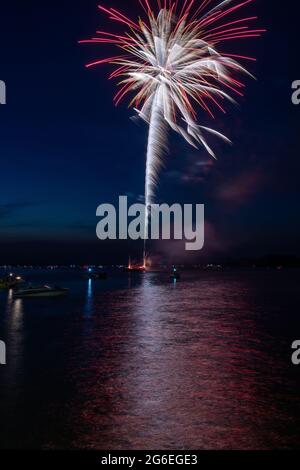 Fuochi d'artificio il 4 luglio sparato da una chiatta su un lago. Foto Stock