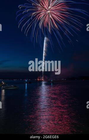 Fuochi d'artificio il 4 luglio sparato da una chiatta su un lago. Foto Stock