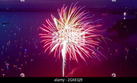 Fuochi d'artificio il 4 luglio sparato da una chiatta su un lago preso con un drone. Foto Stock