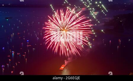 Fuochi d'artificio il 4 luglio sparato da una chiatta su un lago preso con un drone. Foto Stock