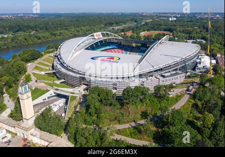 14 giugno 2021, Sassonia, Lipsia: Calcio: Bundesliga, RB Lipsia. Due gru sono alla Red Bull Arena. Il terreno di residenza dei Rasenballers è in fase di ricostruzione. La capacità degli spettatori aumenterà da 42,558 a 47,069 nelle aree in piedi e seduti. L'esterno dello stadio è chiuso con una facciata insonorizzata. L'argine dell'ex Zentralstadion, che comprende l'arena, è stato aperto dietro lo storico campanile per fare spazio ad un nuovo ingresso. RB Leipzig sta investendo nella conversione 60 milioni di euro entro il 2022. (Vista aerea con drone) Foto: Jan Woitas/dpa-Zentralbild/dpa Foto Stock