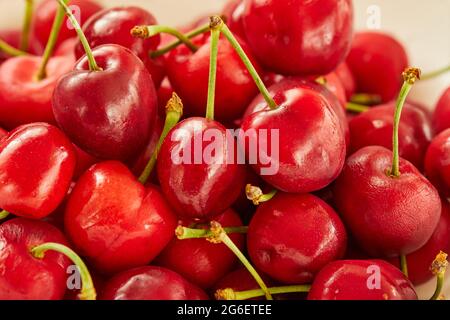 Ciliegie fresche in piatto bianco, pronte da mangiare Foto Stock