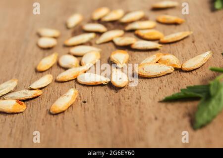 Semi di zucca freschi isolati su superficie di legno Foto Stock