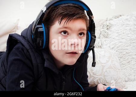 bambino che indossa cuffie per giochi e gioca ai videogiochi Foto Stock