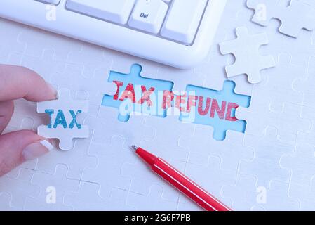 Titolo concettuale rimborso fiscale. Concetto che significa il pagamento in eccesso delle tasse pagate restituite ai proprietari di affari che costruiscono un modello bianco incompiuto di Jigsaw Foto Stock