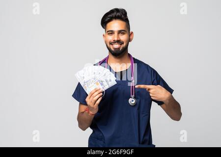 Giovane medico che tiene un mazzo di banconote da un dollaro su sfondo isolato Foto Stock
