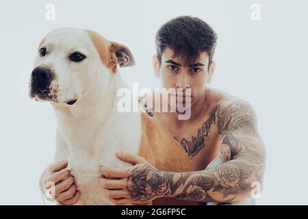 Ritratto di un giovane con tatuaggi e un cane Foto Stock