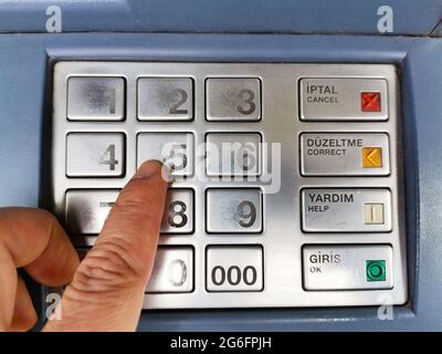 Prelievo di denaro presso l'ATM. Digitazione della password della carta presso ATM. Fare clic con la mano sulla password. Foto Stock