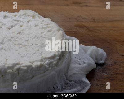 Formaggio feta fresco fatto in casa, fai da te in tessuto di formaggio su legno Foto Stock