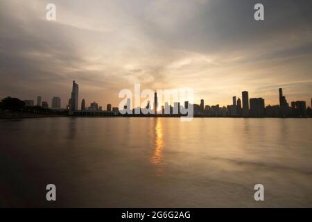 Skyline serale di Chicago con il sole tramontante e gli edifici della città, Chicago, Stati Uniti Foto Stock
