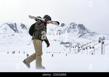 Primo piano di un uomo che cammina in un campo da sci innevato con vista sul Monte Erciyes Foto Stock