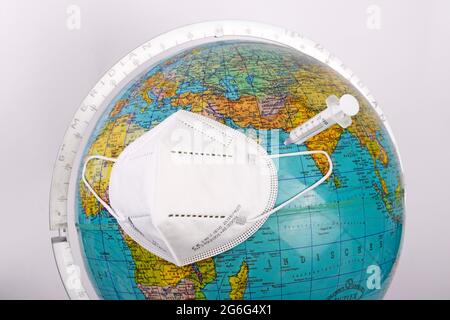 Globo con masksm chirurgico FFP corona pandemie Foto Stock