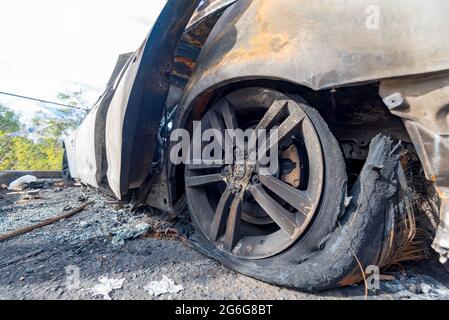 Un primo piano di una scena criminale con un'auto scaricata e bruciata parcheggiata su una strada posteriore a Sydney, New South Wales, Australia Foto Stock