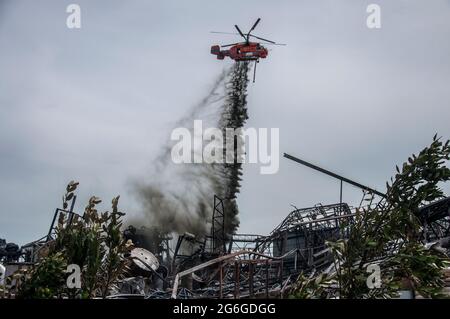 Un elicottero ha visto spruzzare polvere chimica per estinguere l'incendio causato da un'esplosione in una fabbrica di Ming Dih chimica devastata dal fuoco nel distretto di Bang Phli, nella provincia di Samut Prakan. Un'esplosione notturna e un incendio in una fabbrica chimica hanno ucciso una persona e ferito più di 60 altre, Invio di fumo nero nel cielo sopra Samut Prakan's Bang Phli zona a fine Lunedi pomeriggio. I vigili del fuoco utilizzavano elicotteri, tra cui alcuni dell'esercito, per spruzzare schiuma ignifuga sul complesso dell'impianto Ming Dih Chemical Co. (Foto di Peerapon Boonyakiat/SOPA Images/Sipa USA) Foto Stock