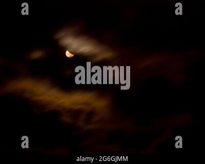 Eclissi lunare parziale coperta da nubi in movimento(16.7.2019) Foto Stock