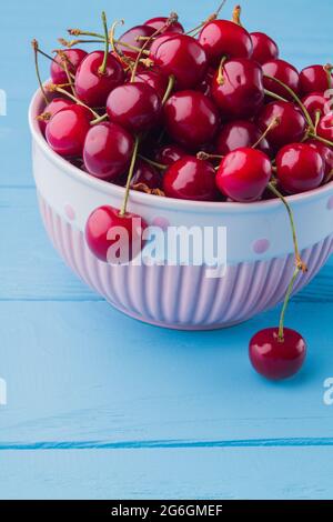 Shot verticale di ciliegie rosse fresche mature nel recipiente. Foto Stock